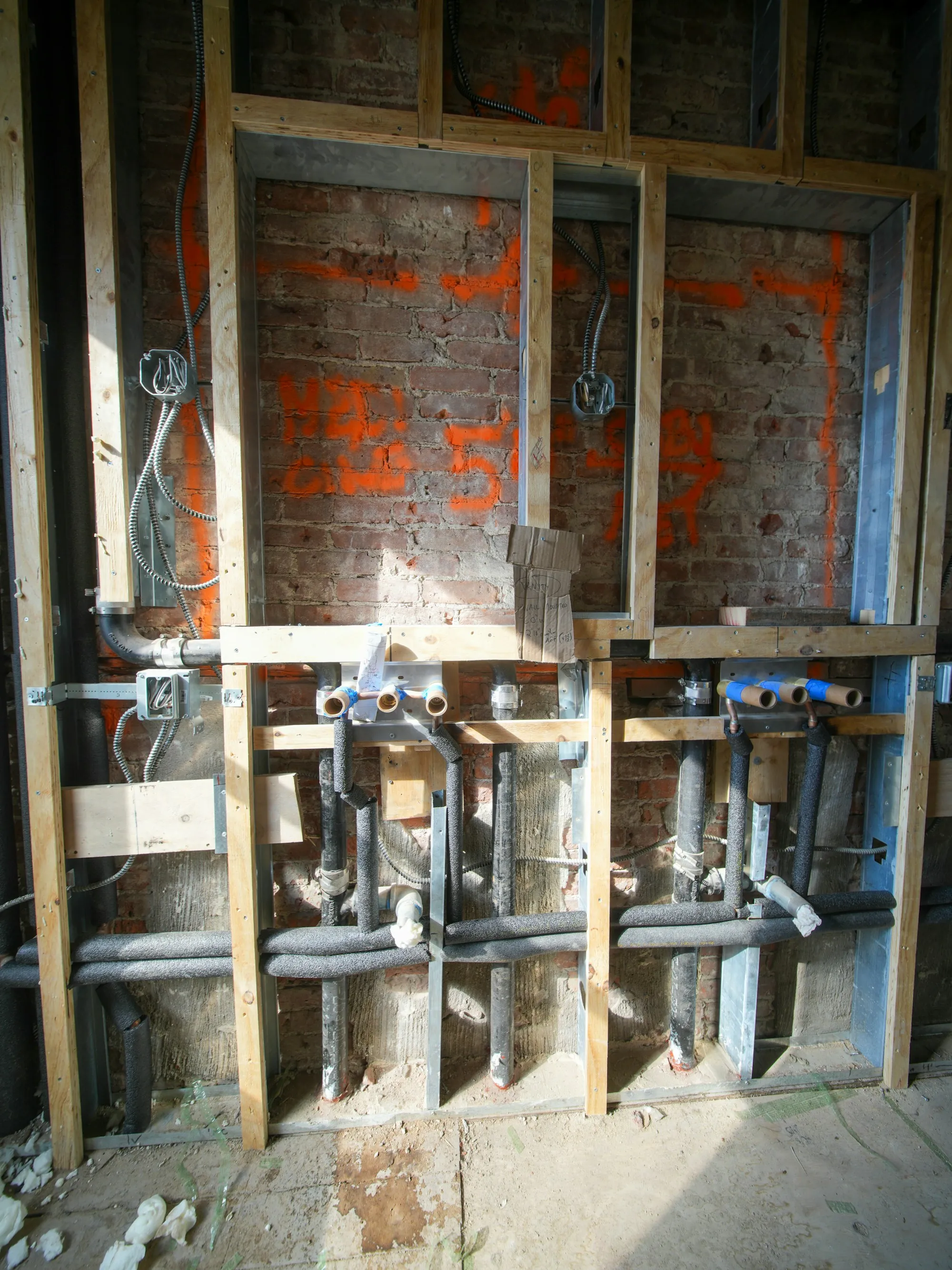 New plumbing lines run inside an open wall during a remodel