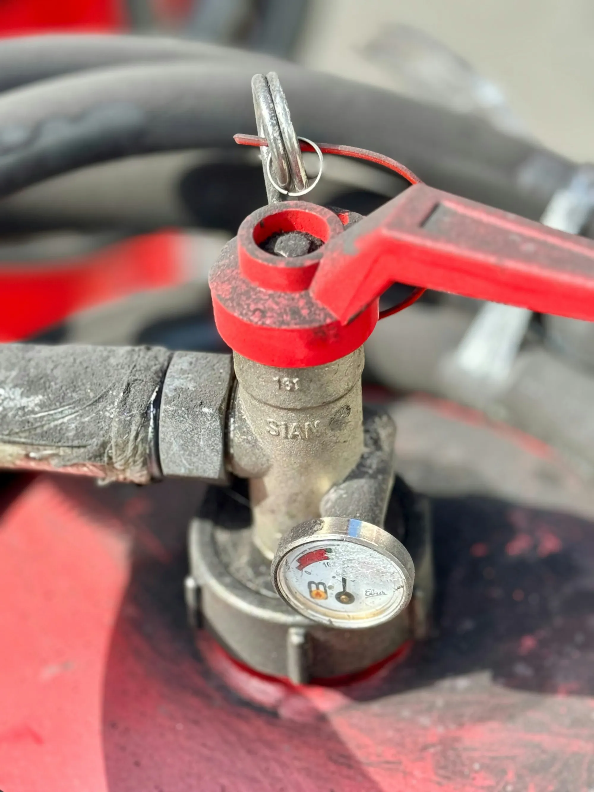 Water Filter Repair & Maintenance in Newport Beach Red valve handle with a pressure gauge on a water line