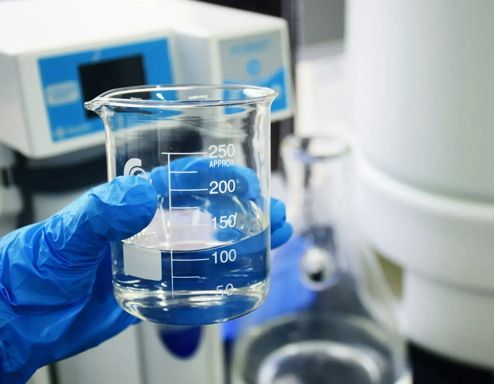 Better Water in Three Straightforward Steps Gloved hand holding a glass beaker of water for testing
